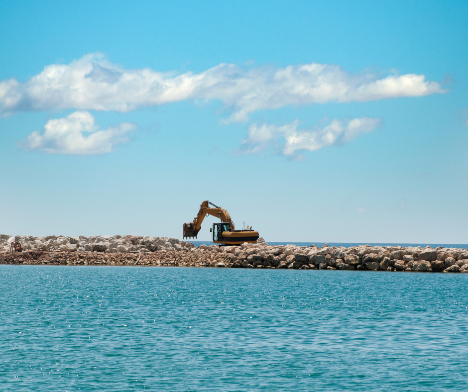 scenery of gray rocks pier on body of water during daytime